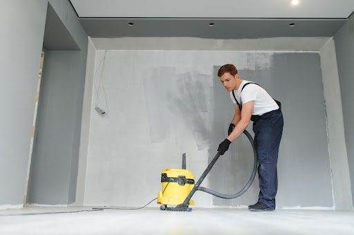 Person cleaning floor with shop vac